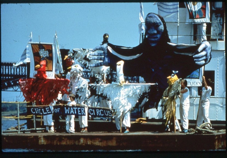 Product Description: 6"x4" Postcard</br></br>Circle of Water arrives in St. Louis, Missouri on a tugboat.</br></br>Photo courtesy of In the Heart of the Beast Puppet and Mask Theater.</br></br>Featured in Circle of Water: Puppetry as an Agent of Change, 2024-2026</br> Postcard - Circle of Water Circus
